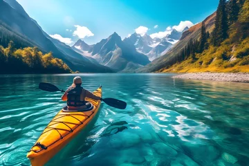 Foto op Canvas A dynamic photo of an individual kayaking on a serene blue lake, surrounded by majestic mountains. © Davivd
