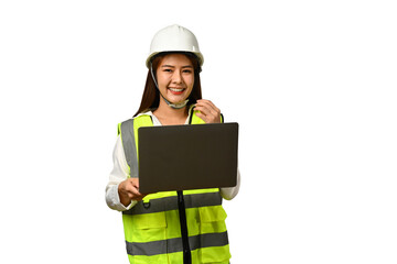 Young female engineer wearing safety vest and hardhat holding laptop isolated on white background