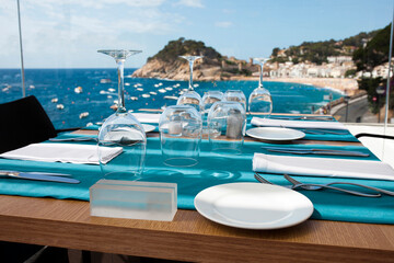 Table with blue cloth and served dishes in restaurant at seaside.