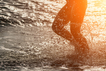Running woman on a summer beach. A woman jogging on the beach at sunrise, with the soft light of the morning sun illuminating the sand and sea, evoking a sense of renewal, energy and health.
