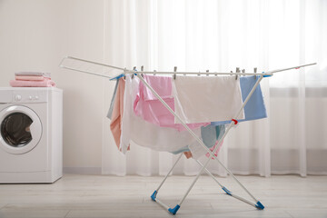 Clean laundry hanging on drying rack indoors - obrazy, fototapety, plakaty