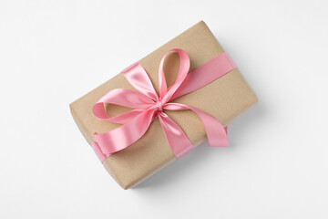 Beautiful gift box with pink bow on white background, top view
