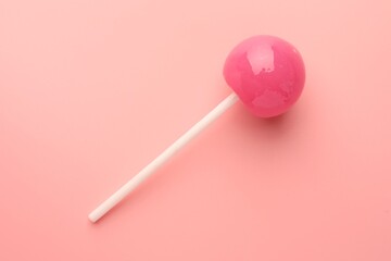 Tasty lollipop on pink background, top view