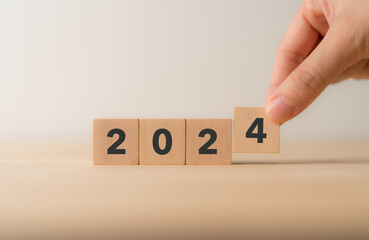 Naklejka premium Starting new year 2024. 2024 on wooden cube blocks. Beginning and start of the new year 2024. Preparation for new year ,life, business, plan, goals, business target and strategy concept.