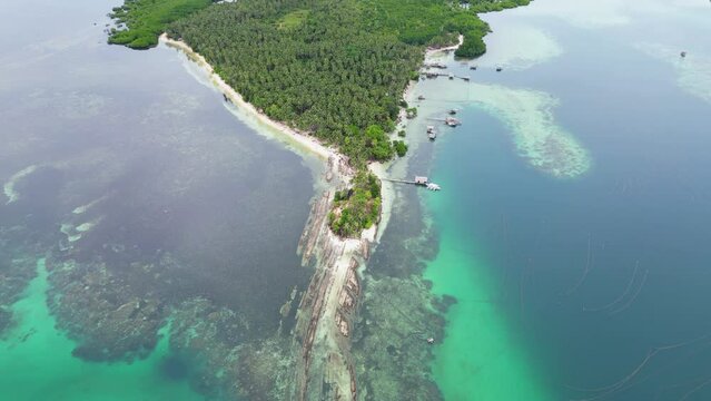 Panoramic aerial overview of Timbayan rock formation, reef, sandy coastline, palm tree forest
