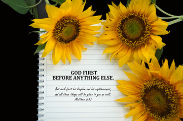 Bible verse quote - God First before anything else. Matthew 6:33 But seek first his kingdom and his righteousness, and all these things will be given to you as well. On notebook and sunflowers.