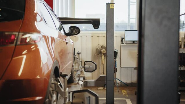 CLose-up car wheel indoors service maintenance repair center against laser sensor equipment diagnostics and 3d wheel alignment. Wheel alignment equipment on a car wheel in a repair station