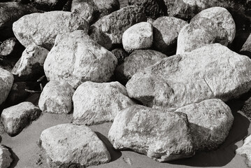 Large stones on the beach outdoors, monochrome photo