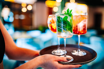glasses alcohol cocktail set on a waiter tray in bar