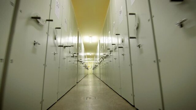 The camera moves between locked metal cabinets filled with old documents. Vilnius, Lithuania - 04 15 2022.
