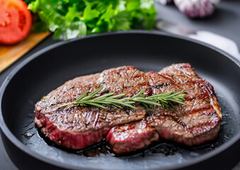 Close up Gourmet Appetizing Roasted Beef Steak and Other Vegetables on a Cast Iron Skillet.