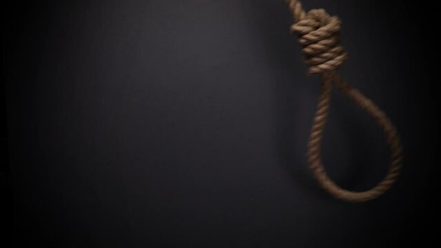 Rope noose with hangman knot on dark background, death penalty concept