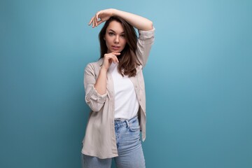 European model appearance young dark-haired lady in informal clothes posing against a blue background