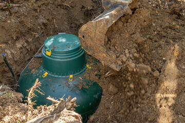 An LPG gas tank is buried with the help of an excavator