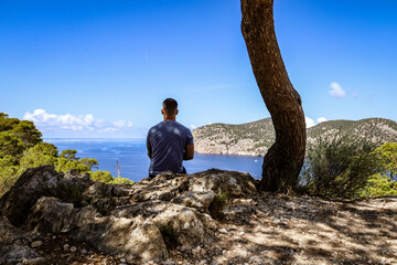 Naklejka na ściany i meble Young man enjoying the view of mountains and Mediterranean sea