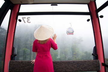 Woman tourist is sitting on  the Cable car while traveling to Ba Na Hills at da nang, Vietnam.