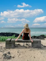 Foto op Plexiglas woman at the beach on a bench vrouw aan het strand op een bankje  © Patricia
