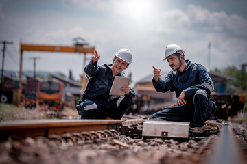 Engineer railway under inspection and checking construction railway switch and maintenence work on railroad station by tablet .Engineer wearing safety uniform and safety helmet in work