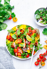 Gourmet salad with grilled chicken and mango salsa, tomato, cilantro, onion and lettuce in mexican style, white kitchen table background, top view