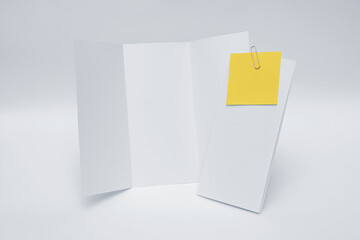 Folded paper with notes attached on white background