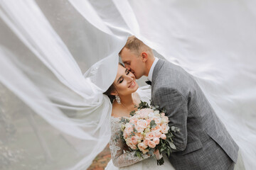 Groom and bride in the park. Autumn wedding in the forest. Happy wedding, loving couple tender...