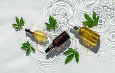 Cbd Oil Bottles, white water background with drops, waves and leaves of hemp, marijuana