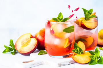 Peach peach tea, iced fruit drink, summer beverage with fresh fruits and mint. Close up with space for text.