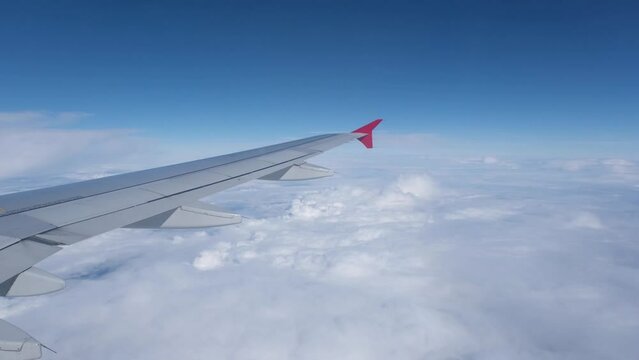 View of the white clouds and Earth from the airplane porthole. Travel concept.