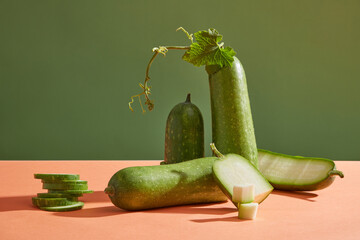 Fresh winter melon and some round slices stacked on each other over a pink plane. Winter melon (Benincasa hispida) is consumed as a regular drink on hot days.
