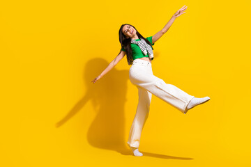 Full size portrait of pretty satisfied girl have good mood dancing empty space ad isolated on yellow color background