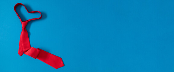Father's day concept. Flat lay top view of red tie on blue background with space for text, advertising and greeting message, banner