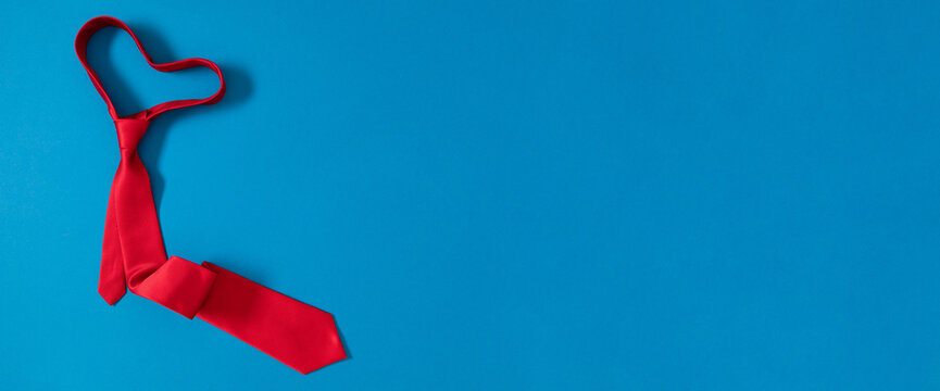 Father's day concept. Flat lay top view of red tie on blue background with space for text, advertising and greeting message, banner