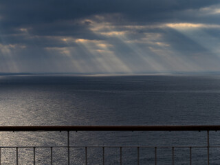 Sonnenaufgang hinter Wolken, beobachtet vom Deck eines Schiffes auf hoher See