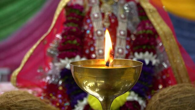 Illuminating Devotion: Lit Brass Lamp with Hindu Goddess Durga Mata Ji during Navratri Celebration