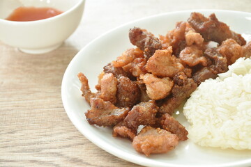 fried salty pork eat with sticky rice on dish dipping spicy chili sauce