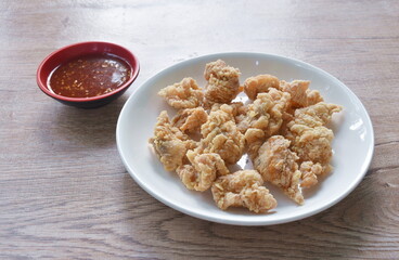 crispy fried Korean chicken with bread crumb and egg yolk on plate dipping barbecue sauce