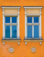 Zdobione okna od mieszkania pomarańczowej kamienicy