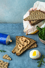 Swedish snack. Cod roe paste on crisp bread  and bitten boiled egg on light blue linen tablecloth.