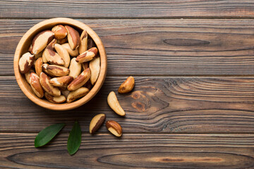 Fresh healthy Brazil nuts in bowl on colored table background. Top view Healthy eating bertholletia concept. Super foods
