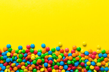 Mixed collection of colorful candy, on colored background. Flat lay, top view. frame of colorful chocolate coated candy