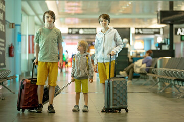 Children, brothers, traveling for summer holiday, waiting at the airport to board the aircraft