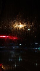 Abstract background street after rain photography wallpaper. Cyberpunk style rain and lanterns street japan. Headlights light at night rain drops on glass blurred abstract background