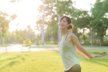 Female jogger. Fit young Asian woman with green sportswear stretching muscle in park before running and enjoying a healthy outdoor. Fitness runner girl in public park. Wellness being concept