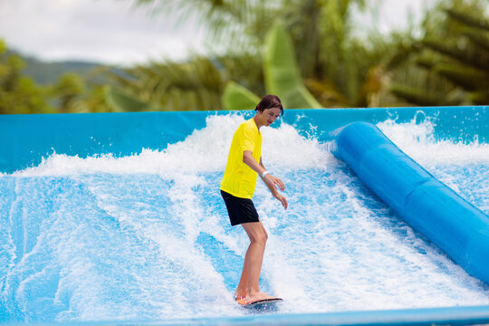 Teenager boy surfing in beach wave simulator