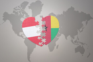 puzzle heart with the national flag of guinea bissau and austria on a world map background.Concept.