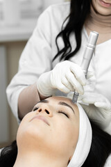 The photo captures the moment when the cosmetologist conducts fractional mesotherapy, providing...