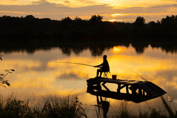lonely young fisherman at sunset