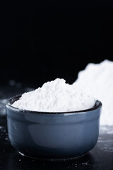 White tapioca starch powder in a bowl, dry cassava root.