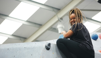 Close Up Of Smiling Woman Reaching Top Of Climbing Wall In Indoor Activity Centre