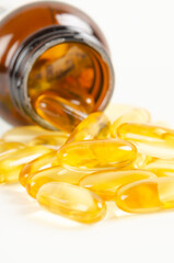 The Fish oil capsules in a glass bottle on white background.